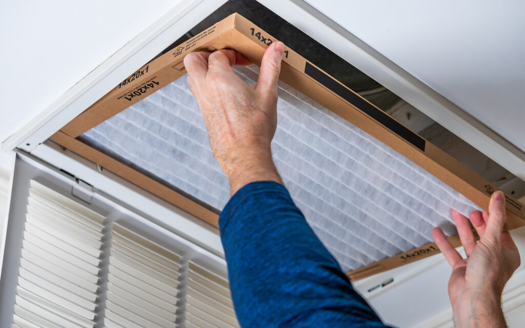 Person adjusting the duct filter in ceiling