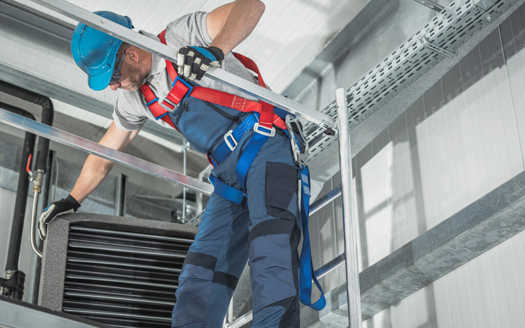 Technician working on ductwork in commercial building