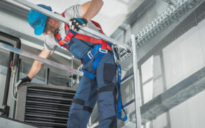 Technician working on ductwork in commercial building