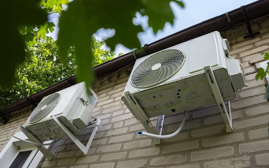Heat pumps on exterior wall of brick house