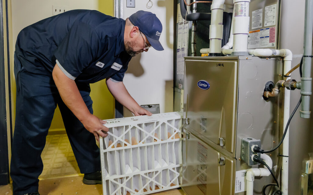 Joe in Cusotm Aire uniform installing a new air filter