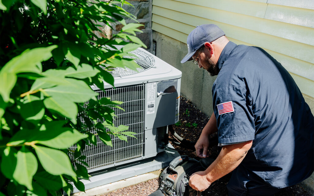 Joe with toolbag looking at exterior Residential cooling unit