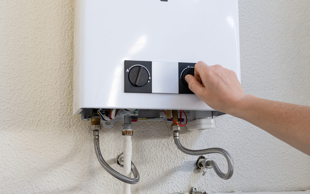 Person adjusting the dials on a residential water heater