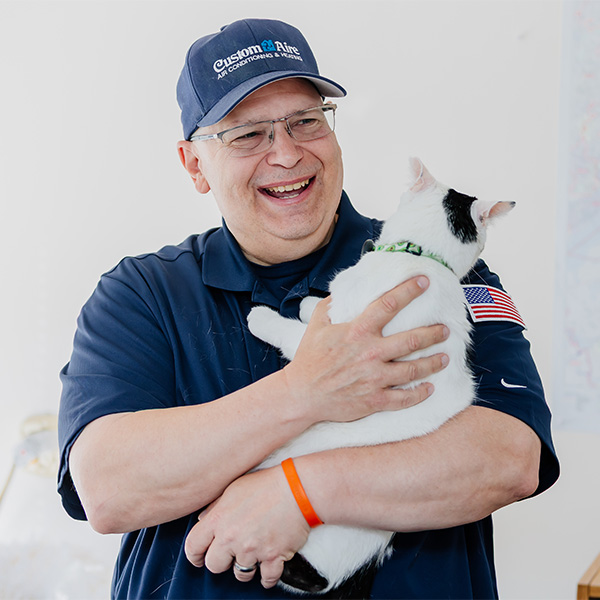 Worker in Custom Aire hat holding cat