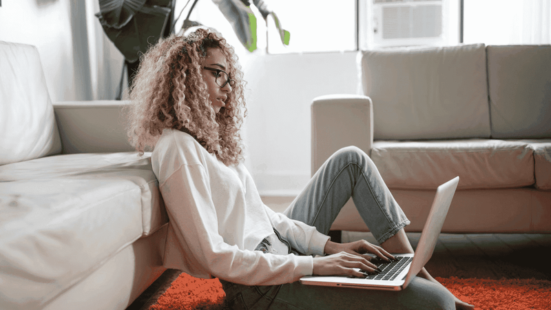 woman at home using laptop on the floor