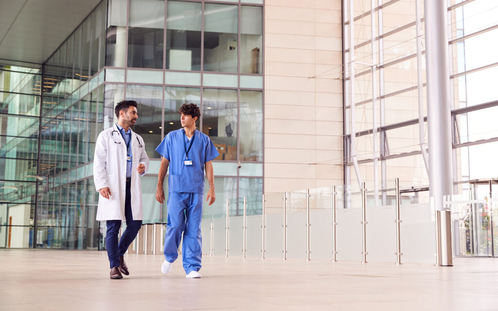 Doctors Walking Through Hospital Discussing Work