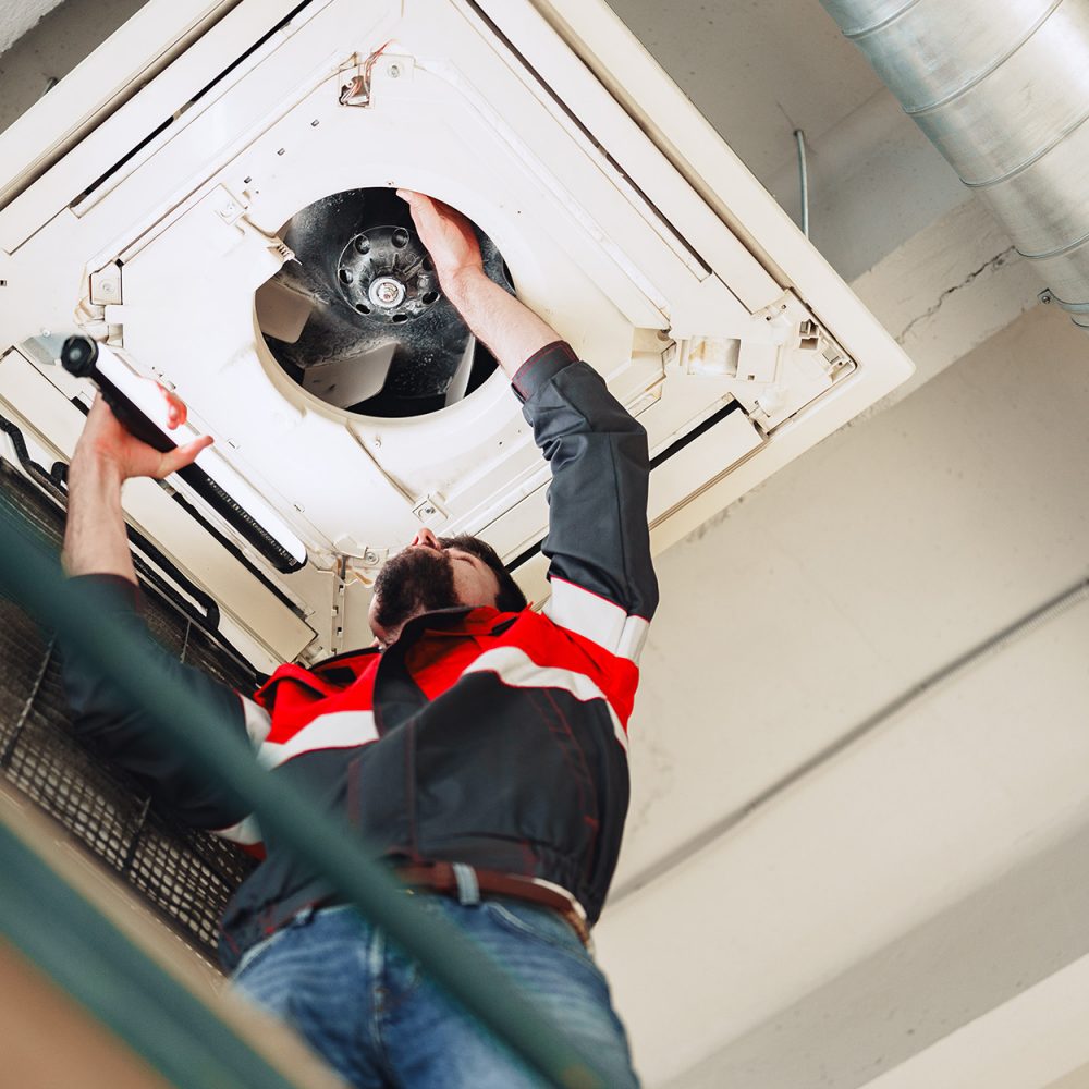 HVAC Technician fixing vent in commercial building